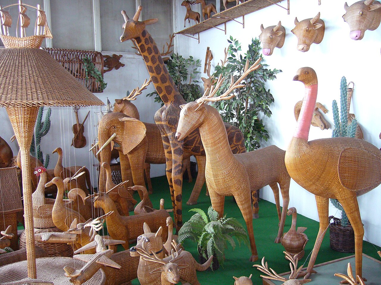 Wicker makers working among baskets and woven figures in Camacha