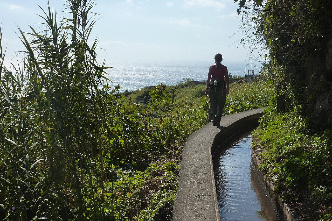 A walker following the narrow path beside a levada above Funchal
