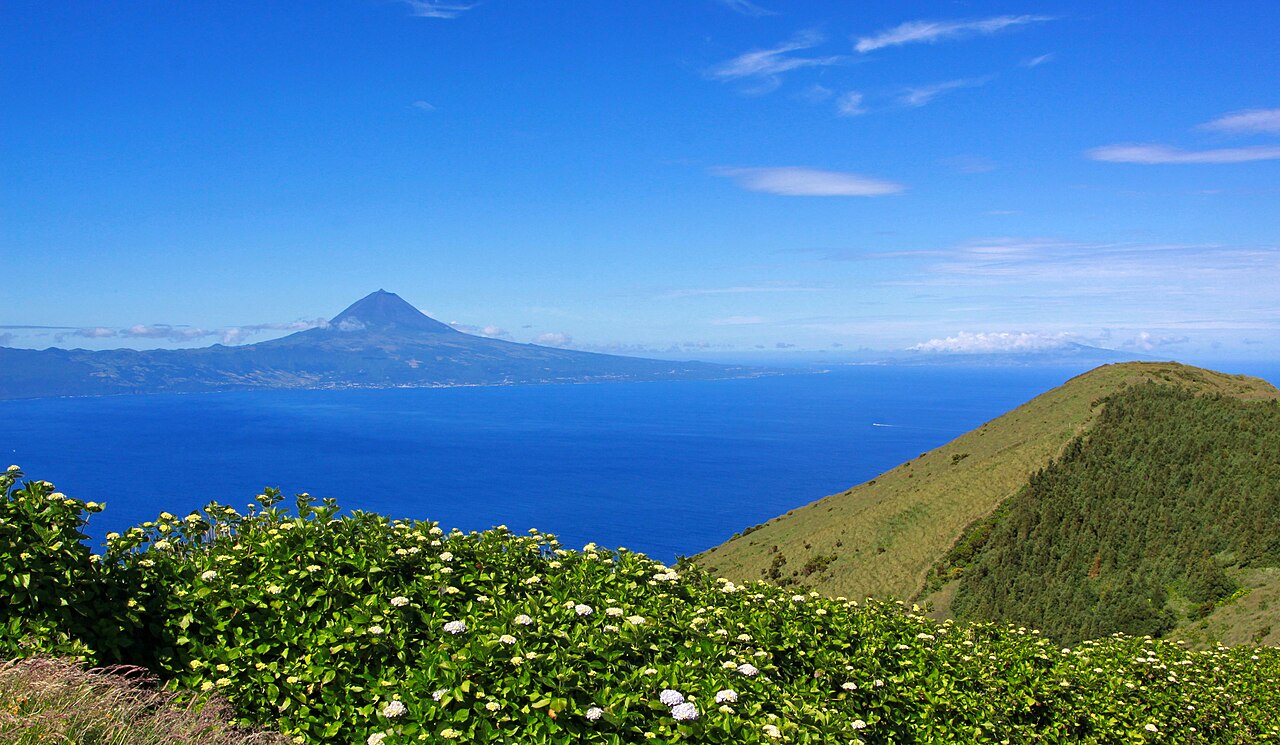 Green slopes on São Jorge with Pico rising across the channel
