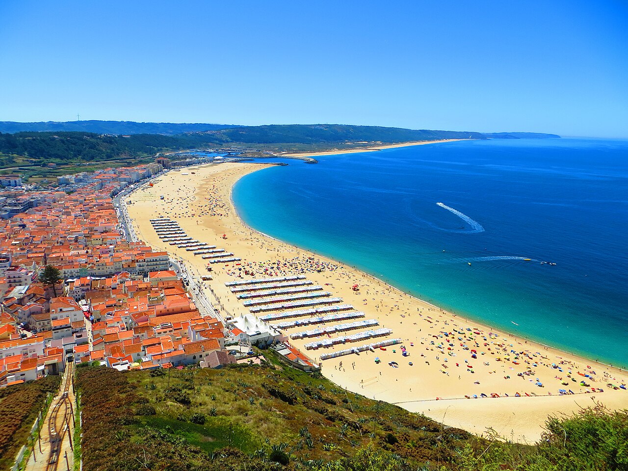 Nazaré's broad beach and red-roofed town seen from the cliff