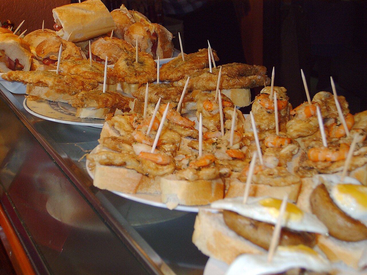 Assorted pintxos arranged on the counter in Bermeo's old port
