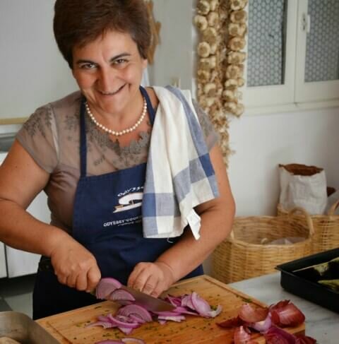 Greek cookery course host Katerina cutting onions
